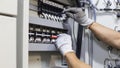 Electrical engineer tests the operation of the electric control cabinet on a regular basis for maintenance Royalty Free Stock Photo