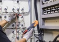 Electrical engineer tests the operation of the electric control cabinet on a regular basis for maintenance