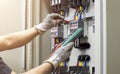 Electrical engineer tests the operation of the electric control cabinet on a regular basis for maintenance.