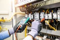 Electrical engineer using digital multi-meter measuring equipment to checking electric current voltage at circuit breaker and Royalty Free Stock Photo