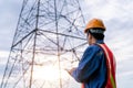 Electrical engineer wear safety clothes standing and watching at the electric power station to view the planning work by producing