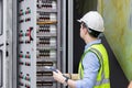 Electrical engineer working in control room. Electrical engineer man checking Power Distribution Cabinet in the control room Royalty Free Stock Photo