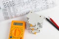 Electrical engineering drawings, circuit breaker and digital multimeter Royalty Free Stock Photo