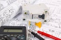 Electrical engineering drawings, modular circuit breaker and digital multimeter. Royalty Free Stock Photo