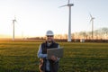 Electrical engineers working at wind turbine power generator station with laptop