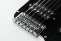 Electrical guitar bridge and metal strings closeup. Electric guitar black and white color, detail. Music instruments