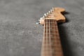 Electrical guitar neck, headstock and metal strings closeup. Electric guitar black and white color, detail. Music instruments