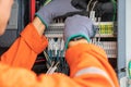 Electrical and instrument technician wiring cable at terminal and junction box.