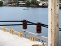 Electrical insulators connected high-voltage cables on power,electric concrete pole. Royalty Free Stock Photo