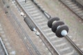 Electrical insulators on the contact wires on the background of a blurred railway track. Macro photo with selective focu Royalty Free Stock Photo