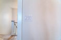 Electrical light switch and wall mounted temperature sensor inside a house Royalty Free Stock Photo