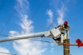 Electrical lineman in crane working on an electric pole damaged by supercell Royalty Free Stock Photo