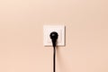 Electrical outlet with plug on beige wall Royalty Free Stock Photo