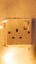 Electrical outlet switch on textured wall with warm light ambiance Royalty Free Stock Photo