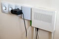 Electrical outlets and internet modem on a cream wall background