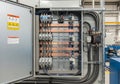 Electrical panel in an industrial setting, featuring multiple circuit breakers and blue wires Royalty Free Stock Photo