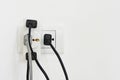 Electrical plug and socket overloaded on white background, copy space Royalty Free Stock Photo