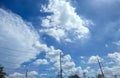 Electrical poles and wires against a sky with clouds