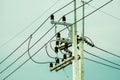 Electrical post by the road with power line cables, transformers and phone lines Royalty Free Stock Photo