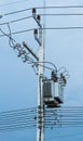 Electrical post by the road with power line cables, transformers and phone lines Royalty Free Stock Photo