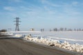 Electrical power line pillar on snow in front of blue sky Royalty Free Stock Photo