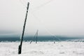 Electrical power lines with hoarfrost on the wooden electric poles on countryside in the winter Royalty Free Stock Photo