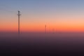 Electrical Power Lines and Pylons disappear over the horizon with Misty Sunrise, Sunset