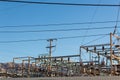 Electrical power transfer station against mountain range, blue sky Royalty Free Stock Photo