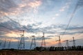 Electrical pylons and high voltage power lines at sunset background. Group silhouette of transmission towers Royalty Free Stock Photo