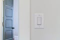 Electrical rocker light switch on white wall against blurry door background