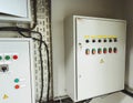 Electrical room of residential or commercial building. Multiple smart meters, main power breaker, meter stacks and cabinets.