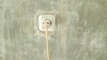 Electrical sockets and plugs attached to the wall, cables hanging down Royalty Free Stock Photo