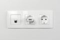 Electrical sockets on the wall with black connection internet plug and white wire. Adapter from the charging device with usb input Royalty Free Stock Photo