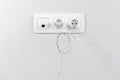 Electrical sockets on the wall with black connection internet plug and white wire. Adapter from the charging device with usb input Royalty Free Stock Photo