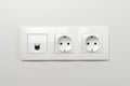 Electrical sockets on the wall with black connection internet plug and white wire. Socket set with usb cord and electricity cable Royalty Free Stock Photo