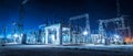 Electrical substation at night with illuminated structures and power lines Royalty Free Stock Photo