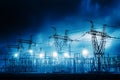 Electrical substation towers illuminated at dusk under a dramatic sky Royalty Free Stock Photo