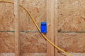 An electrical switch box made of plastic with wires attached to wooden frame beams Royalty Free Stock Photo