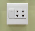 Electrical switch and plug on light green wall Royalty Free Stock Photo