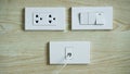 Electrical switch and plug on wooden wall, AC power plugs and sockets,White Plugs socket and Cable TV outlet receptacle on wall