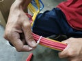 An electrical technician apply zip ties to a bundle of wires. Royalty Free Stock Photo