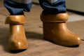 Electrical technician is putting on special protective shoes in power station. Electrician wears rubber boots for safety