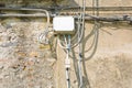 Electrical and telephone cables with plastic junction box against an old plaster wall Royalty Free Stock Photo