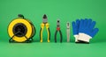 Electrical Tools Array: Cable Reel, Pliers, and Gloves on Green Backdrop Royalty Free Stock Photo