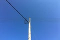 Electrical tower with blue sky background. Old simple rural weathered wooden utility pole with parallel cables and insulators on Royalty Free Stock Photo