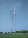 Electrical tower in the field on blue sky background