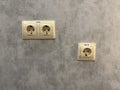 Electrical wall sockets on textured concrete wall background with space for copy or design Royalty Free Stock Photo