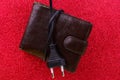 An electrical wire tied into a knot on old decrepit wallet. The concept of the energy crisis and electricity inflation Royalty Free Stock Photo