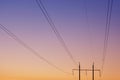 Electrical wires against the dawn sky, in the background two pillars, focusing on the wires, concept Royalty Free Stock Photo