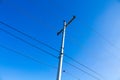 Electrical wires on a pole on blue sky background.